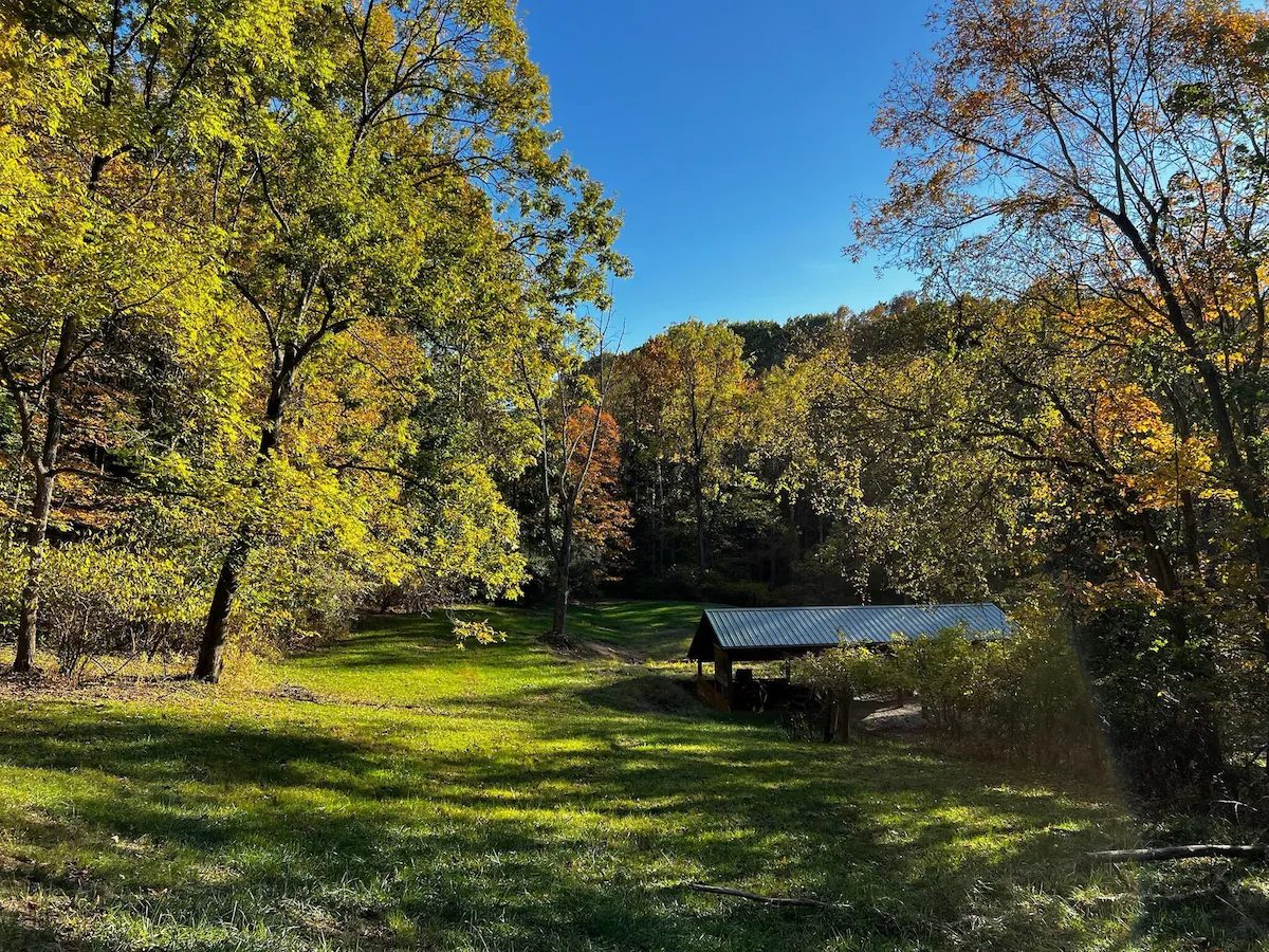 The open meadow and pavilion under fall color and blue sky